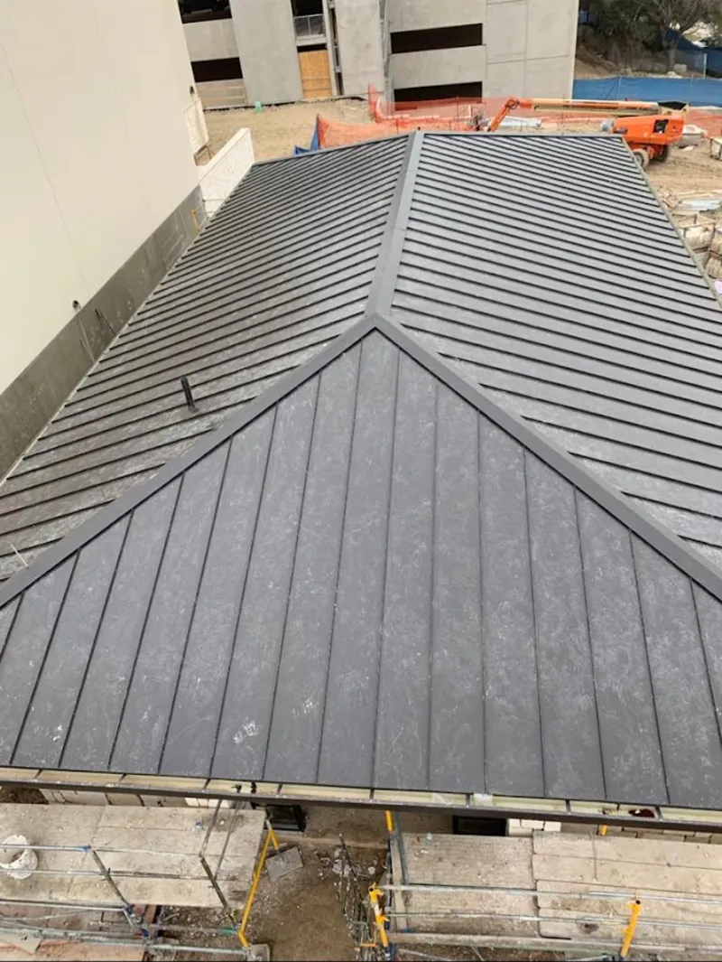 Commercial metal roof construction with crane equipment in Gladeview